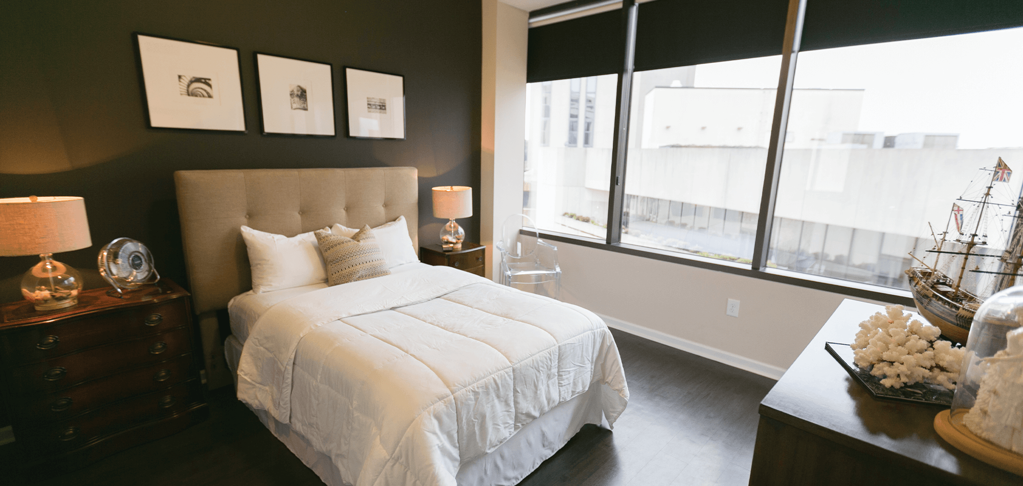 Bedroom view of the 40 four building with large windows and room darkening shades.