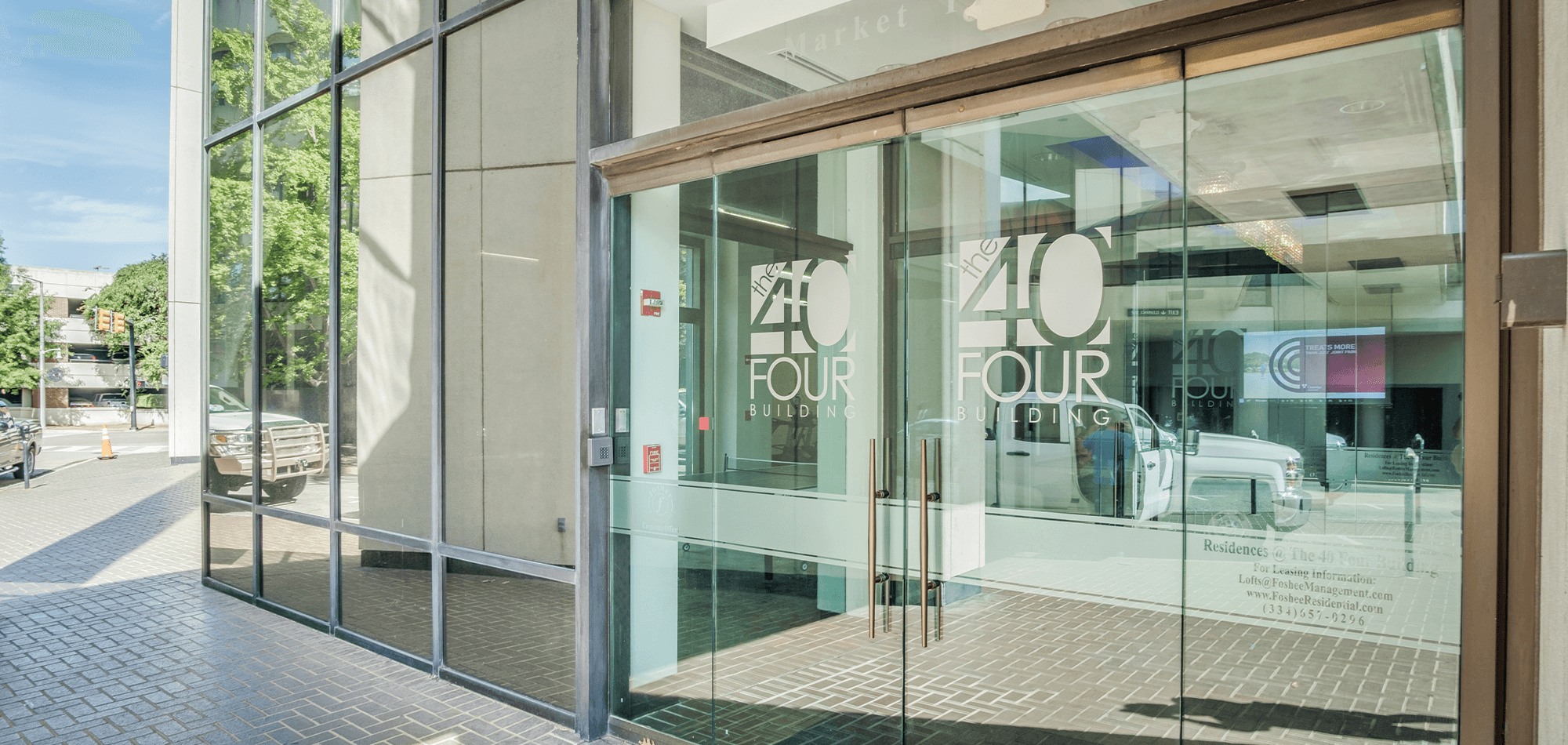 Entrance to the 40 Four Building with glass doors and mirrored windows