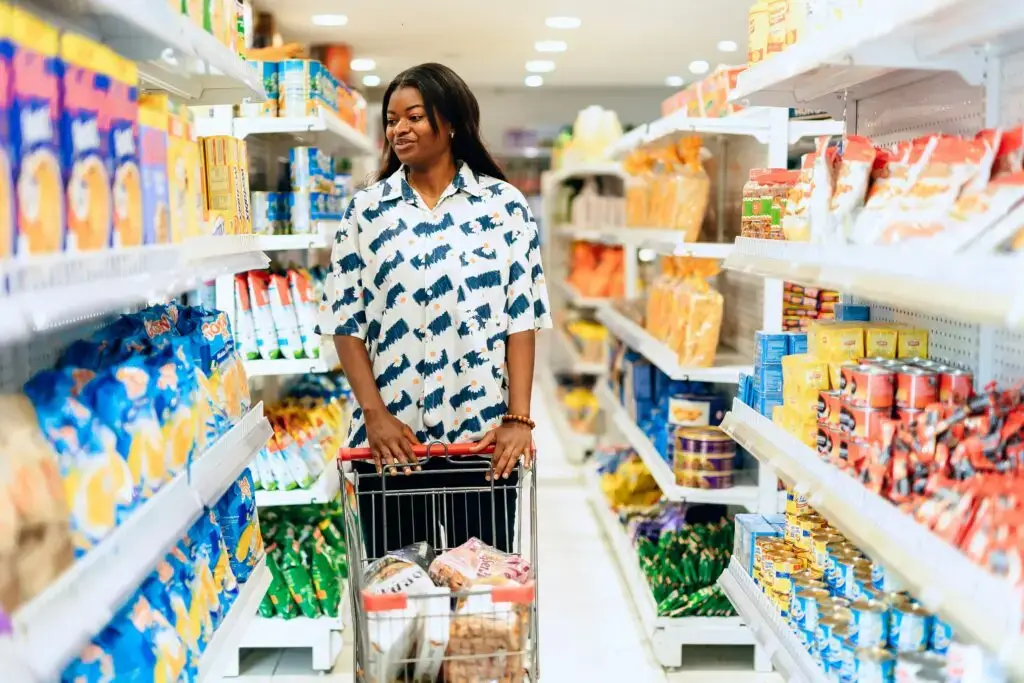 Woman walking down the grocery aisle, stretching your grocery budget