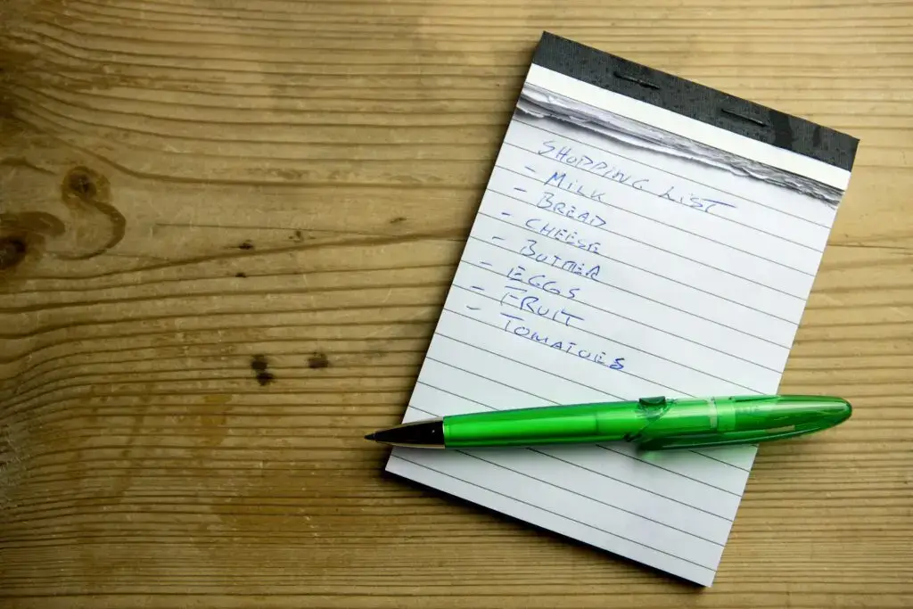 Writing out a grocery list to stretch your grocery budget